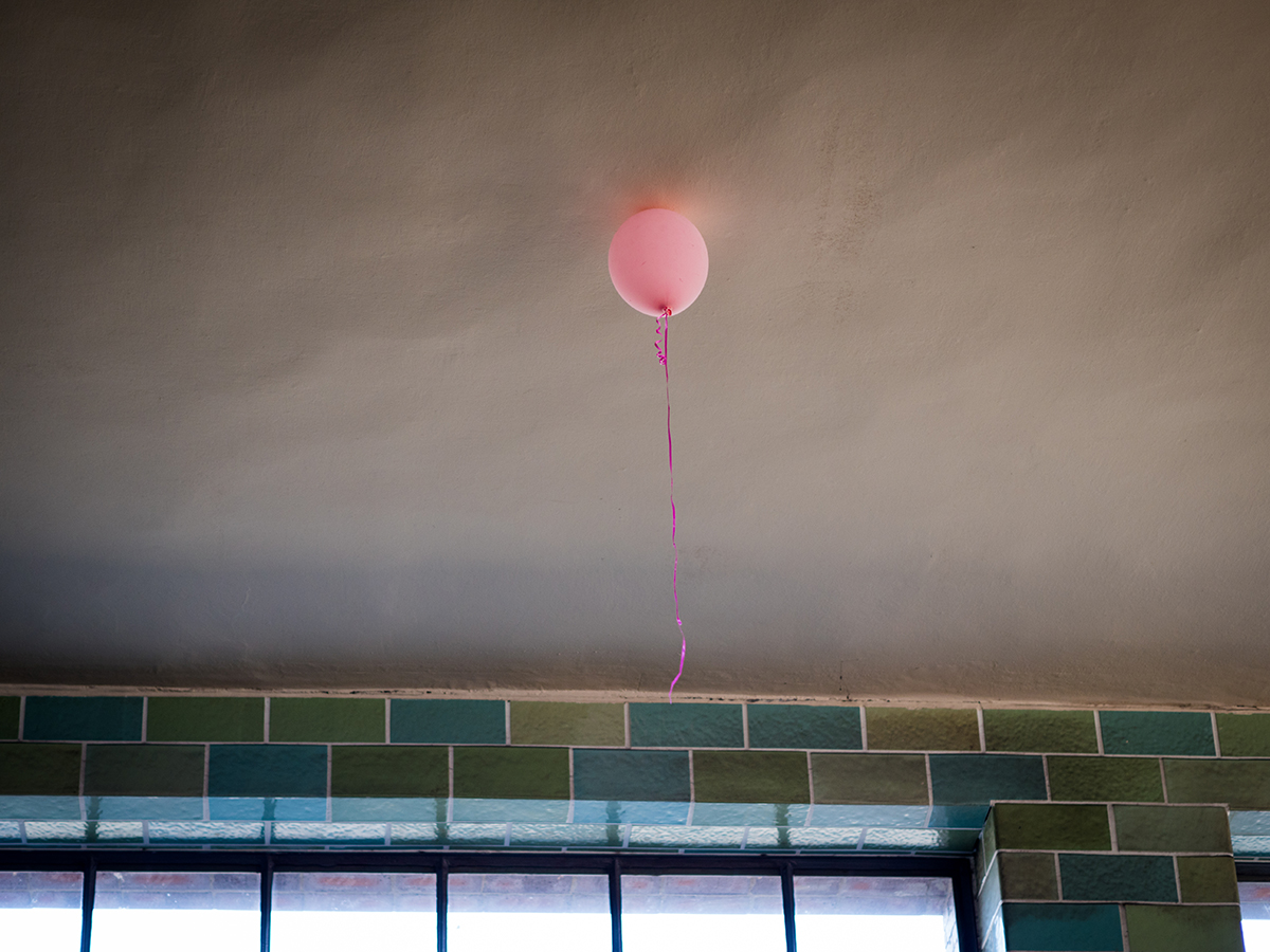 rosafarbener Luftballon klebt an der Decke
